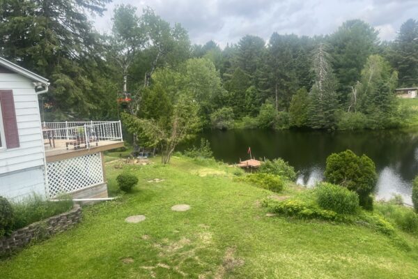 Maison avec terrasse et vue sur lac pittoresque.