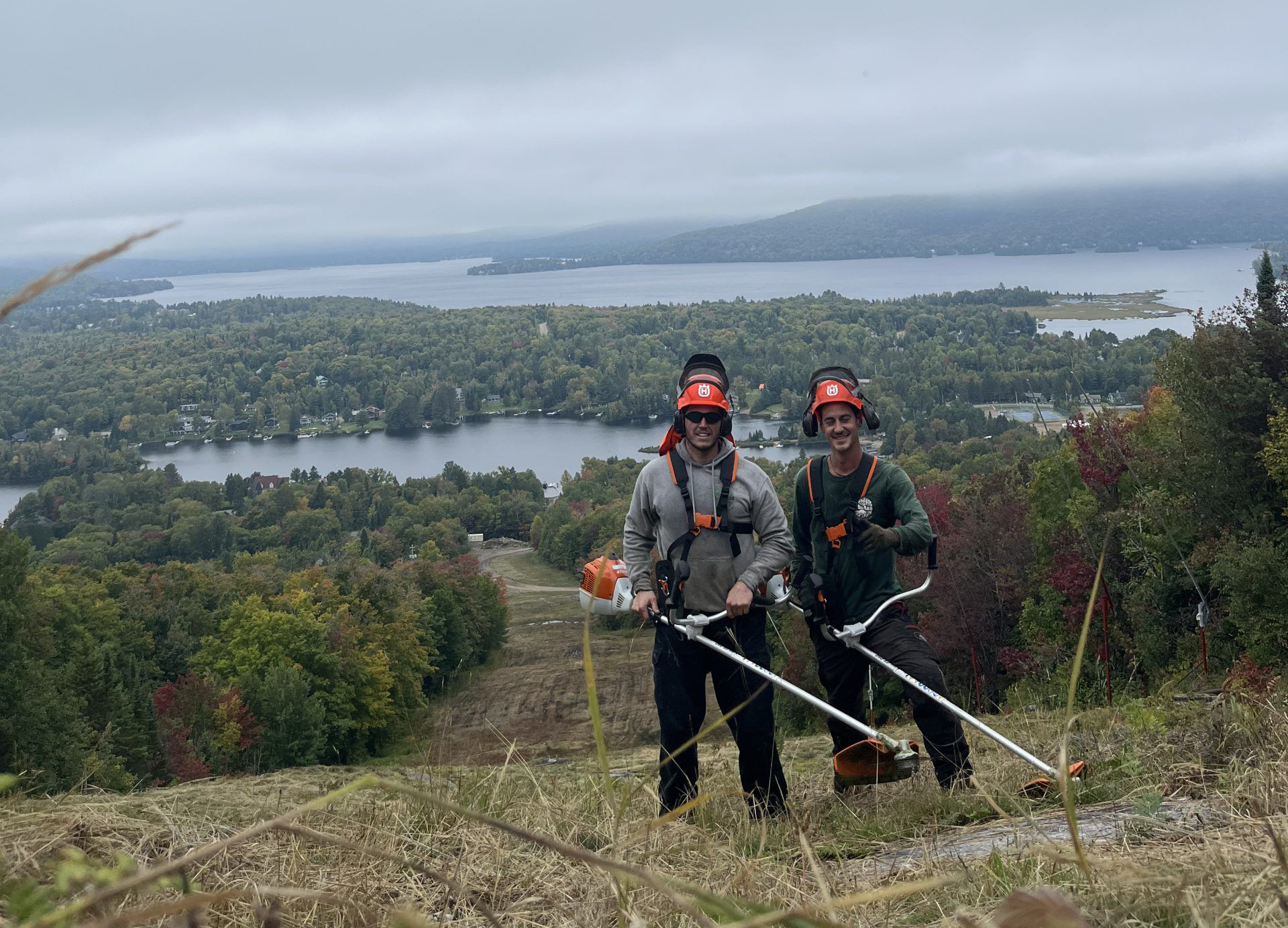 Travailleurs sur une colline avec vue sur lac.
